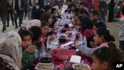Fələstinlilər Ramazan ayının ilk günü Qəzza zolağının cənubunda Rəfah şəhərində iftar süfrəsinə toplaşıb, 1 mart 2025.