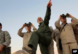 FILE - A photo by the government-controlled Syrian Central Military Media, shows Iran's Army Chief of Staff Maj. Gen. Mohammad Bagheri, left, and other senior officers on the front line in the northern province of Aleppo, Syria, Oct. 20, 2017.