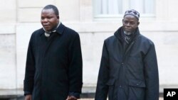 L'archevêque de Bangui, Dieudonné Nzapalainga,(à gauche), et Oumar Kobine Layama, en route pour un entretien avec le président français François Hollande à l'Elysée, à Paris, le jeudi 23 janvier 2014. 