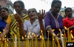 Sri Lankan Christian devotees light candles as they pray at a barricade near St. Anthony's Shrine in Colombo, April 28, 2019, a week after a series of bomb blasts targeting churches and luxury hotels on Easter Sunday in Sri Lanka.