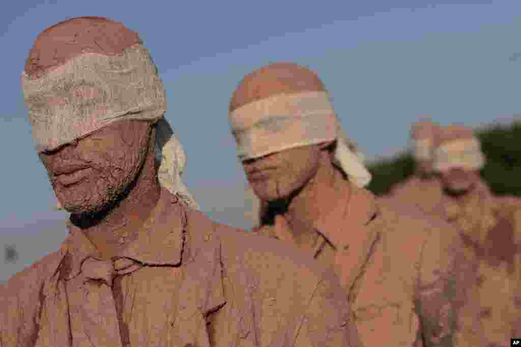 Artists from Sao Paulo's Deviation Collective group take part in a performance called "Cegos" or Blind, in front of the Planalto Presidential Palace, in Brasilia, Brazil, Aug. 25, 2016. "Cegos" is defined by the group as an open work of different readings; "reducing our existence to the productive function and consumption, overwork, imprisonment and the petrification of life."