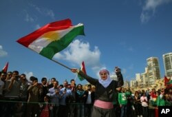 Suriah Kurd Nazdan, yang melarikan diri dari rumahnya di Qamishli, Suriah, mengenakan pakaian tradisional saat ia menari dan mengibarkan bendera Kurdi, selama perayaan hari Nowruz, di Beirut, Lebanon, 21 Maret 2016. (Foto: AP)