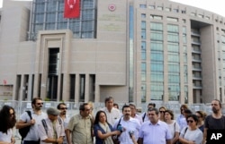 FILE - Journalist are seen gathered outside a court building to support a colleague who was detained in connection with the investigation launched into the recent failed coup attempt in Turkey, in Istanbul, July 27, 2016.