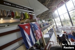 U.S. and Cuban flags hang on a wall at the U.S pavilion during the Havana International Fair (FIHAV), Havana, Cuba, Nov. 2, 2015.