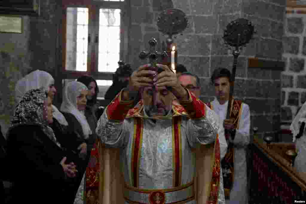 A Syrian Christian priest leads a mass on Christmas at the Virgin Mary Syriac Orthodox Church in Diyarbakir, Turkey, Dec. 25, 2018.