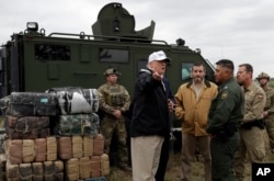 FILE - President Donald Trump tours the U.S. border with Mexico at the Rio Grande in McAllen, Texas, Jan. 10, 2019.