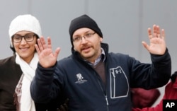 U.S. journalist Jason Rezaian gestures next to his wife Yeganeh Salehi as he poses for media people in front of Landstuhl Regional Medical Center in Landstuhl, Germany, Wednesday, Jan. 20, 2016.