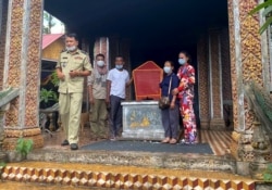 Relatives stand next to a coffin bearing the body of former Khmer Rouge prison chief Kaing Guek Eav, also known as Duch, at a pagoda in Phnom Penh on September 2, 2020.