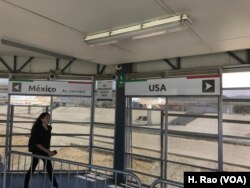 A woman walks toward the sign pointing to the United States in this undated photo.