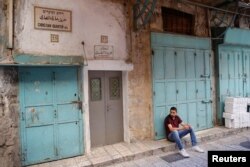 A sign in multiple languages reflects the Christian Quarter's cultural mix. A recent wave of violence has made minority Christians uneasy.