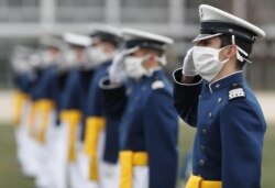 Para kadet yang mengenakan masker memberi hormat pada upacara kelulusan untuk Kelas 2020 di Akademi Angkatan Udara A.S., Sabtu, 18 April 2020, di Akademi Angkatan Udara, selama wabah corona. (Foto: AP)