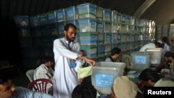 Afghan election workers count ballot papers for an audit of the presidential run-off in Kabul, Afghanistan, Aug. 6, 2014.
