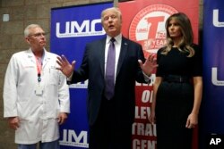 President Donald Trump talks as first lady Melania Trump and surgeon Dr. John Fildes listens at the University Medical Center after Trump met with survivors of the mass shooting, Oct. 4, 2017, in Las Vegas.