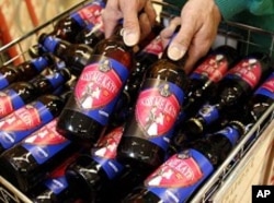A worker poses with bottles of "Kiss Me Kate" ale at a Morrisons supermarket in Leicester.