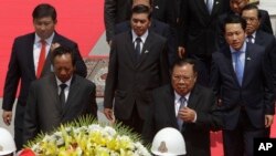 Laos President Bounnhang Vorachith, foreground right, walks together with Cambodian Defense Minister Tea Banh, foreground left, during a ceremony to pay respects at the Monument Independence in Phnom Penh, Cambodia, Wednesday, Feb. 22, 2017.