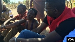 Sixty-one-year-old Virgilance Tsabora, center, in a sleeveless black shirt, looks after her 89-year-old mother, who cannot walk, talk, see or hear properly. Tsabora, of Mudzi District. Zimbabwe, hopes efforts by the International Federation of Red Cross and Red Crescent Societies will end her hunger. (S. Mhofu/VOA)
