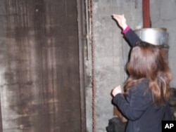 Rebecca Maitland points out the chute where merchants used to drop their gold from the street above.