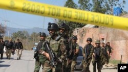 Pakistani soldiers cordon off the area of suicide bombing in Charsadda, Pakistan, Feb. 21, 2017. Police say three suicide bombers attacked a courthouse in northwestern Pakistan