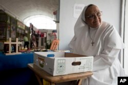 Sister Carmen Negrón, 64, sells handmade rosaries and religious icons in the Plaza del Mercado in San Juan, Puerto Rico, April 17, 2019. Negrón says she's noticed a drop in sales because of what seems to be fewer people in the area.