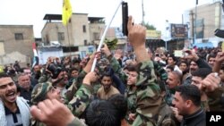 Protesters shout slogans and brandish weapons during a demonstration calling for the immediate withdrawal of Turkish troops from northern Iraq, in Basra, Iraq, Dec. 12, 2015.