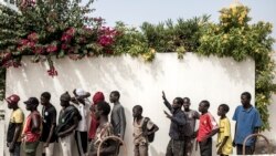 Les enfants des rues, également appelés Talibe, font la queue pour recevoir de la nourriture et des boissons distribuées par Village Pilote à Dakar, le 10 avril 2020.