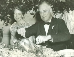 First lady Eleanor Roosevelt watches as President Franklin D. Roosevelt carves the traditional Thanksgiving turkey during supper at Warm Springs, Georgia, Nove. 29, 1935. (Franklin D. Roosevelt Presidential Library and Museum/White House Historical Association)