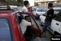 Drivers wait in a line to fill up their vehicles with fuel near a gasoline pump as the fuel crisis continues in Kathmandu, Nepal, Oct. 1, 2015.