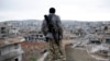 FILE - A Syrian Kurdish sniper looks at the rubble in the Syrian city of Kobani.
