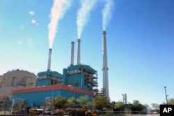 FILE - Smoke rises from the Colstrip Steam Electric Station, a coal burning power plant. Nine northeastern states are charging their power plants for their greenhouse gas emissions.