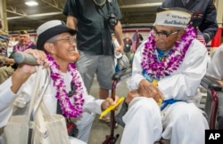 Kathleen Chavez, left, talks with her father, Ray Chavez, age 104, of the USS Condor, the oldest living survivor from the Pearl Harbor attacks, along with the remaining living survivors of the USS Arizona gathered at the World War II Valor in the Pacific National Monument at Joint Base Pearl Harbor-Hickam in Honolulu, Dec. 7, 2016.