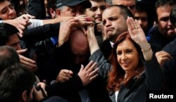 Former Argentine President Cristina Fernandez de Kirchner waves to supporters as she leaves a Justice building where she attended court to answer questions over a probe into the sale of U.S. dollar futures contracts at below-market rates by the central bank.
