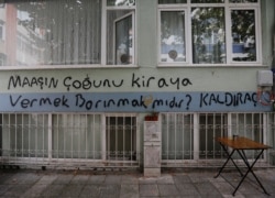 FILE - Graffiti on a wall reads, "Does getting shelter mean paying most of your salary for rent?" in Istanbul, Turkey Oct. 15, 2021.