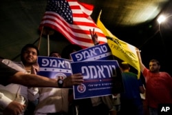 FILE - Israelis wave flags and hold signs during a rally in Jerusalem in support of Donald Trump.
