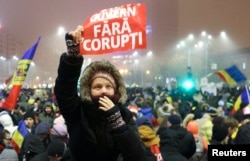 A woman holds up a sign that reads ' government without corruption' during a demonstration of thousands of Romanians against their government in Bucharest, Romania, Feb. 6, 2017.