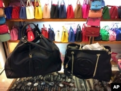 Counterfeit branded bags appear on display in a room hidden from the public area of a popular shopping mall in Beijing, China, March 11, 2015.