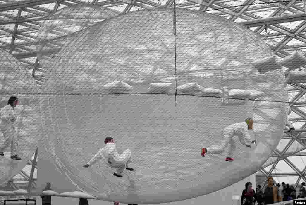 Para pengunjung berusaha memanjat sebuah karya seni 'In Orbit' karya artis Tomas Saraceno dari Argentina di museum Kunstsammlung di kota Düsseldorf, Jerman.