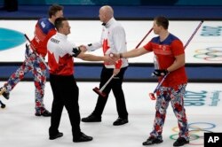 Norway's Christoffer Svae, right, shakes hands with Canada's Ben Herbert after their match at the 2018 Winter Olympics in Gangneung, South Korea, Feb. 15, 2018. At the Pyeongchang Olympics, curlers and their fans agree: In an era of vitriol and venom, curling may be the perfect antidote to our troubled times.
