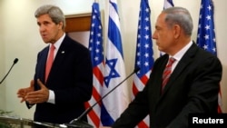 Israeli Prime Minister Benjamin Netanyahu (R) listens as U.S. Secretary of State John Kerry speaks during a news conference following a meeting at Netanyahu's office in Jerusalem, Dec. 5, 2013.
