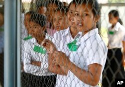រូបឯកសារ៖ សិស្សានុសិស្សខ្មែរ​ឈរ​នៅ​ច្រក​ចូល​សាលសវនាការ​នៃសាលាក្តី​ខ្មែរ​ក្រហម​នៅ​ជាយ​រាជធានី​ភ្នំពេញ​កាល​ពី​ថ្ងៃ​ទី​៦​ ខែ​កុម្ភៈ ឆ្នាំ​២០១៥ នៅ​មុនសាវនាការមួយ​ដើម្បីជំនុំ​ជម្រះ​អតីត​មេដឹកនាំ​ខ្មែរ​ក្រហម ខៀវ សំផន និង​ នួន ជា។ (AP Photo/Heng Sinith)
