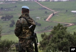 FILE - A U.N. peacekeeper looks to the U.N.-demarcated "Blue Line" border between Lebanon and Israel, Feb. 24, 2015.