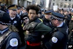 FILE - Lamon Reccord is taken into custody by Chicago police officers during a march calling for Chicago Mayor Rahm Emanuel and Cook County State's Attorney Anita Alvarez to resign, Dec. 9, 2015.