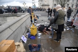 A woman lies injured after a shooting incident on Westminster Bridge in London, March 22, 2017.