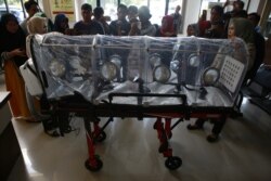 Seorang petugas kesehatan memperlihatkan tandu untuk membawa pasien yang terinfeksi virus corona dari bandara ke rumah sakit, di Lampung, 28 Januari 2020. (Foto: AFP)
