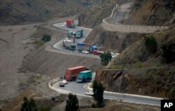 Trucks carry goods to neighboring Afghanistan through the Khyber Pass in Pakistani tribal area, March 21, 2017. A Pakistani border official says hundreds of trucks have crossed into Afghanistan after the border reopened for the first time in a month.