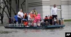 Residents are evacuated from their homes surrounded by floodwaters from Tropical Storm Harvey, Aug. 27, 2017, in Houston, Texas.