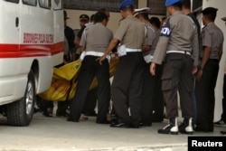 Police carry body bags, one of which is believed to contain the remains of Santoso, the country's most-wanted militant, killed in a clash with security forces, from an ambulance at a hospital in Palu, Central Sulawesi, Indonesia, July 19, 2016.