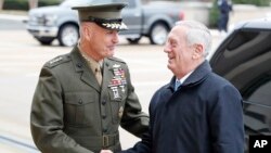 FILE - Chairman of the Joint Chiefs Gen. Joseph Dunford, left, shakes hands with Secretary of Defense James Mattis as Mattis arrives at the Pentagon in Washington, Jan. 21, 2017.