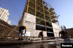 FILE - Laborers work at a construction site in Tehran, Iran, Jan. 20, 2016. Iranian President Hassan Rouhani said May 8, 2018, that the U.S. would not succeed in hurting the Iranian economy by reimposing nuclear-related sanctions.