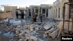 People gather at the site of a bombing in the city of Ramadi, west of Baghdad, Iraq, Nov. 6, 2014.