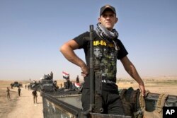 FILE - Iraqi special forces soldiers deployed for an offensive to retake Mosul from Islamic State militants prepare to move out from a camp near Khazer, Iraq, Oct. 14, 2016.